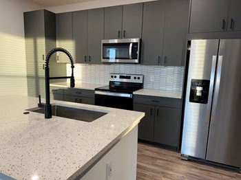 A kitchen with granite counter tops and stainless steel appliances